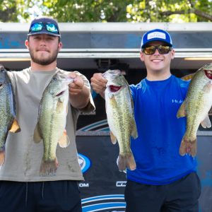 Anglers Kaden Buchmann and Chase Wodzinski holding bass fish at a tournament weigh-in.